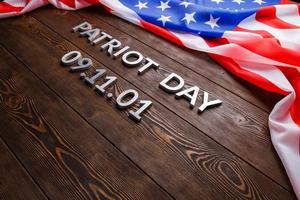 words patriot day laid with silver letters on wooden surface with usa flag photo