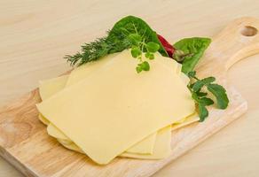 Sliced sheese on wooden board and wooden background photo