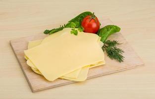 Sliced sheese on wooden board and wooden background photo