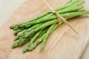 Asparagus on wooden board and wooden background photo