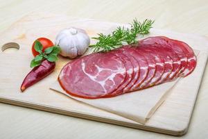 Sliced Ham on wooden board and wooden background photo