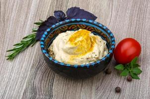 Hummus in a bowl on wooden background photo