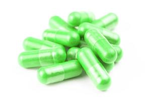 pile of ufo green organic capsules isolated on white background closeup with selective focus photo