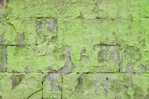 peeled off old green paint on flat rough brick wall surface - full frame background and texture photo