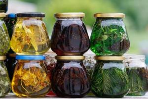 glass jars with favoured honey - with linden, herbs and pine needles, close-up photo