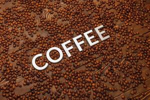 word coffee laid with silver letters on wooden surface covered with coffee beans photo