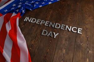 the words independence day laid on brown wooden planks surface with crumpled united states of america flag photo