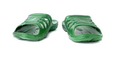 pair of cheap durable green rubber slippers isolated on white background. photo