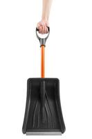 white hand holding small black plastic snow shovel, isolated photo