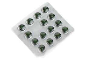 blister pack of green spirulina pills isolated on white background photo