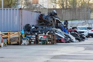 pile of broken plastic car bumpers behind a car dealership and service center photo