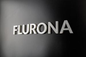 la palabra flurona colocada con letras de metal plateado sobre fondo negro brillante foto
