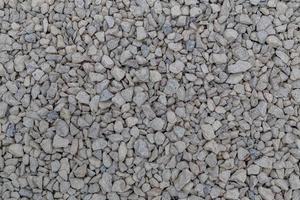 Dry white limestone ballast flat full frame background. Small gray dusty broken macadam stones texture. photo