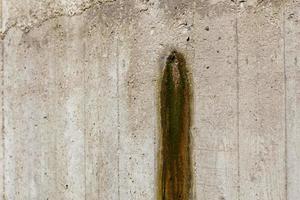 Weeping hole with slurry stain on a concrete retention wall. Close-up. photo
