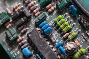 dark background of old electronic circuit board closeup with dus photo