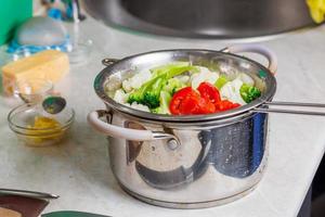 chopped boiled vegetables in colander in stainless steel cooking pot close-up photo