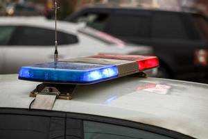 police car lights in city street at winter day with cars traffic in blurry background photo