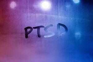 abreviatura ptsd - trastorno de estrés postraumático - escrito a mano en el vidrio de la ventana húmeda nocturna foto