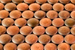 close-up background of many orange organic powder tablets laid tight in one layer on flat surface photo