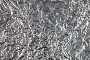 crumpled aluminium foil flat background and texture photo
