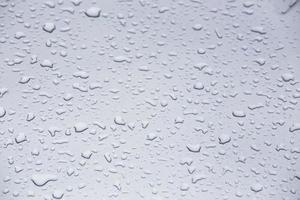 water drops on grey glass surface, full-frame closeup background with selective focus photo