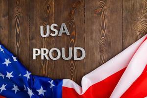 palabras usa orgullo colocadas con letras de metal plateado en una superficie de madera marrón con la bandera de los estados unidos de américa foto