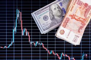 US dollar and russian ruble banknote stacks over digital screen with exchange chart, USD RUB depreciation concept, directly above view photo