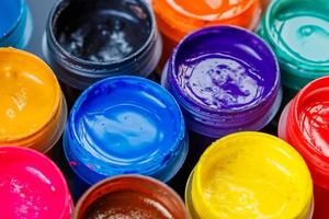 full-frame close-up background of opened small gouache paint jars photo