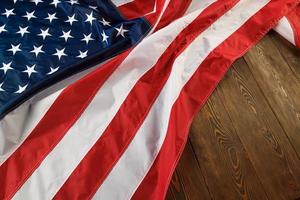 crumpled usa flag on flat textured wooden surface background photo