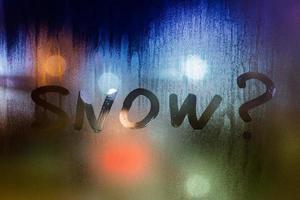 question snow written on night wet window glass close-up with bokeh background photo