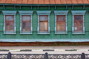 classic russian wooden house with 5 windows on it, front view poor condition photo