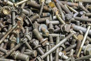 full frame background of used automobile bolts heap, old and dirty photo