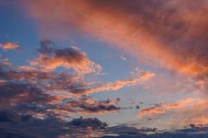 nubes de cúmulo en el cielo nocturno retroiluminado con puesta de sol foto