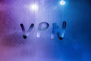 an abbreviation VPN - virtual private network drawed by finger on night wet glass photo