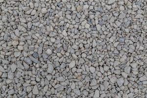 Dry white limestone ballast flat full frame background. Small gray dusty broken macadam stones texture. photo