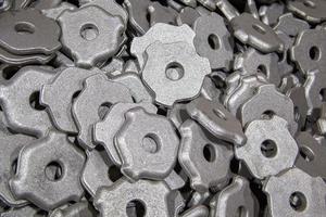 heap of gray steel forgings after shot blasting - close-up natural heavy industrial pattern with selective focus photo