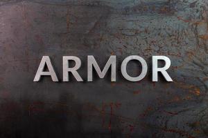 the word armor laid with silver metal letters on rusted iron flat surface background photo