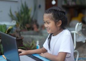 Cute little asian girl using laptop photo