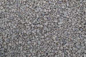 Dry white limestone ballast flat full frame background. Small gray dusty broken macadam stones texture. photo