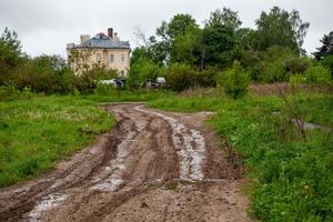 dirty clay mud road with puddles and tire tracks - closeup with selective focus and linear perspective photo