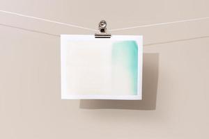 instant photo frame with green and beige patches hanging on a rope