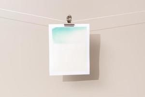 instant photo frame with green and beige patches hanging on a rope