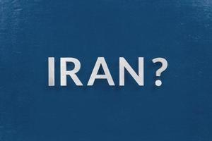 a question iran laid with silver metal letters on classic blue board in flat lay with central composition photo