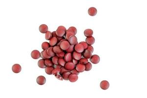 a small pile of red compacted powder pills isolated on white background in linear perspective photo