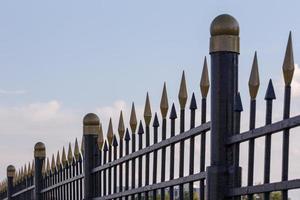 black iron fence with golden decorative elements in linear perspective photo