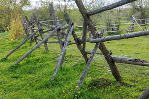 rustic gray thin log fence at summer day photo