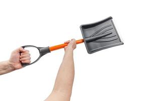 two white hands holding small black plastic snow shovel, isolated photo