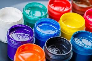 full-frame close-up background of opened small gouache paint jars photo