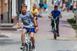 TULA, RUSSIA, JUNE 1, 2014, Teenagers riding bicycles on sidewalk in summer city at sunny day with selective focus. photo
