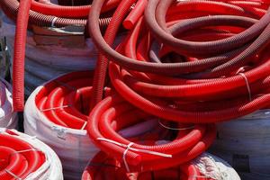 red corrugated PVC pipes for cable lay on the construction site photo